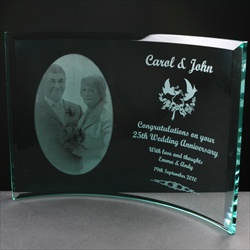 A special 10mm Curved Clear Glass Frame which is self-supporting, engraved for a 25th Wedding Anniversary, with an image of the couple and suitable text to commemorate the Wedding Anniversary.
